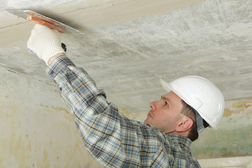 Contractor in white hardhat pargeting the ceiling